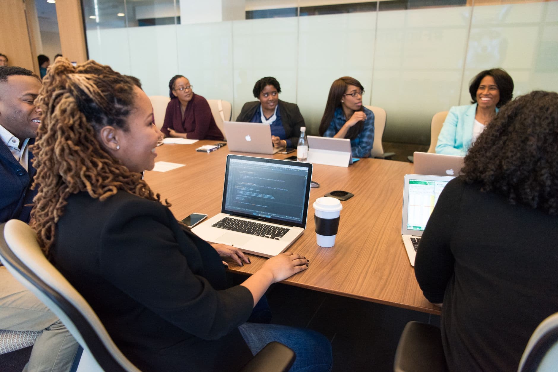Colleagues meeting around laptops in a business office